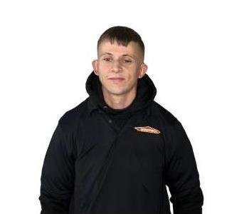 male employees smiling in front of wooden wall background