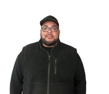 male employee smiling in front of wooden wall background