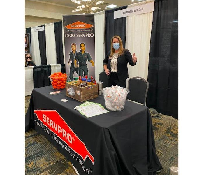 female employee standing behind table at trade show event