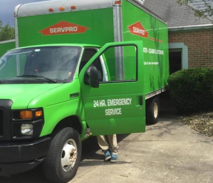 green van with driver door open outside of residential home