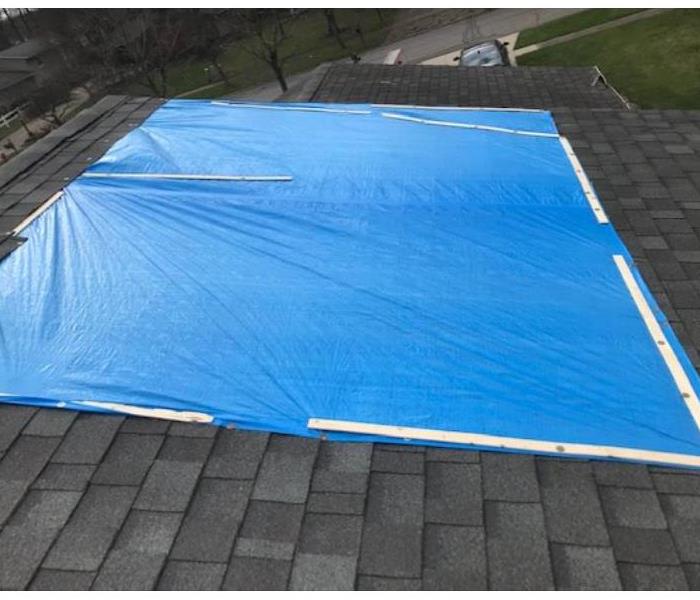 blue tarp on roof after storm damage