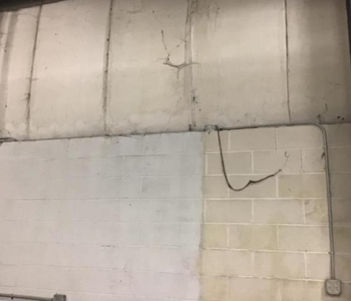 dust and debris buildup on white walls in commercial warehouse